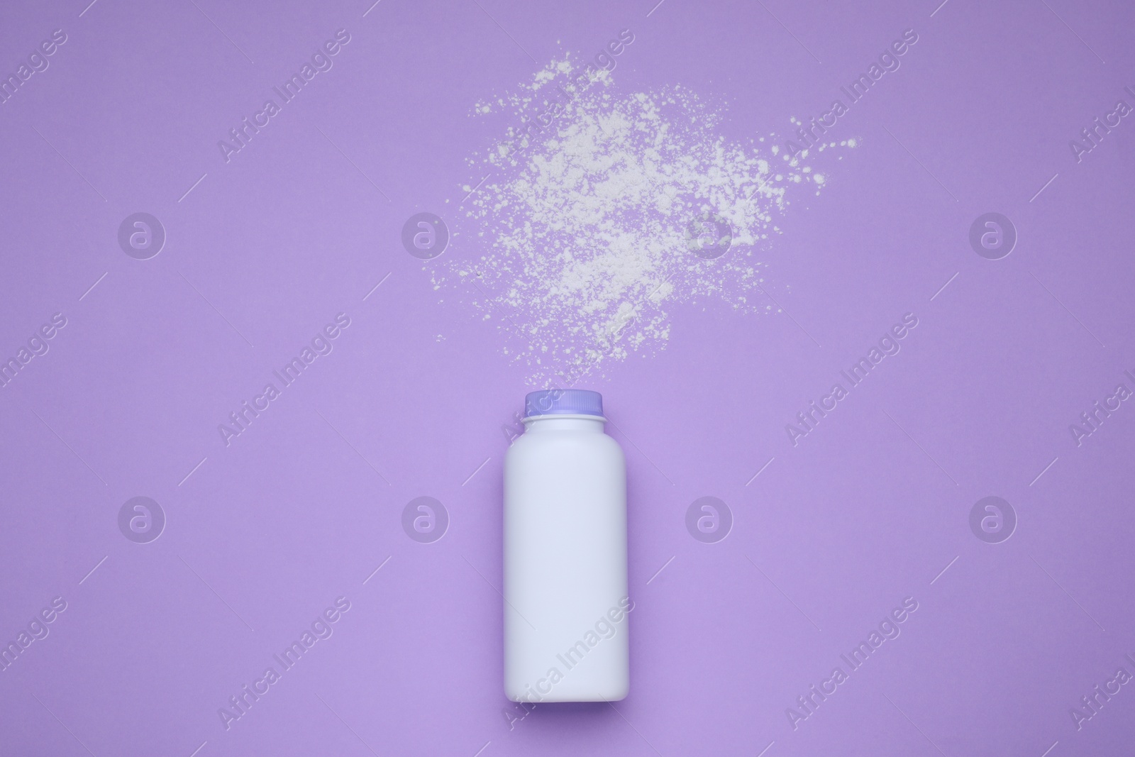 Photo of Bottle and scattered dusting powder on violet background, top view. Baby cosmetic product