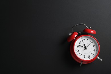 Photo of Alarm clock and space for text on black background, above view. School time