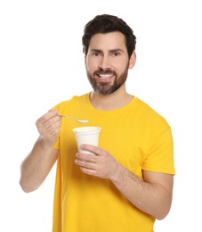 Photo of Handsome man with delicious yogurt and spoon on white background