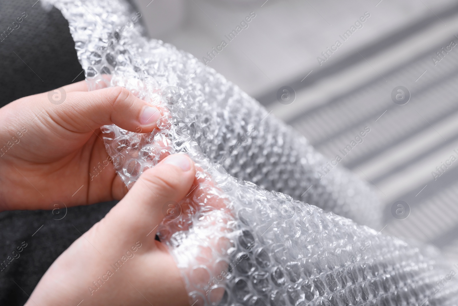 Photo of Boy popping bubble wrap, closeup. Stress relief