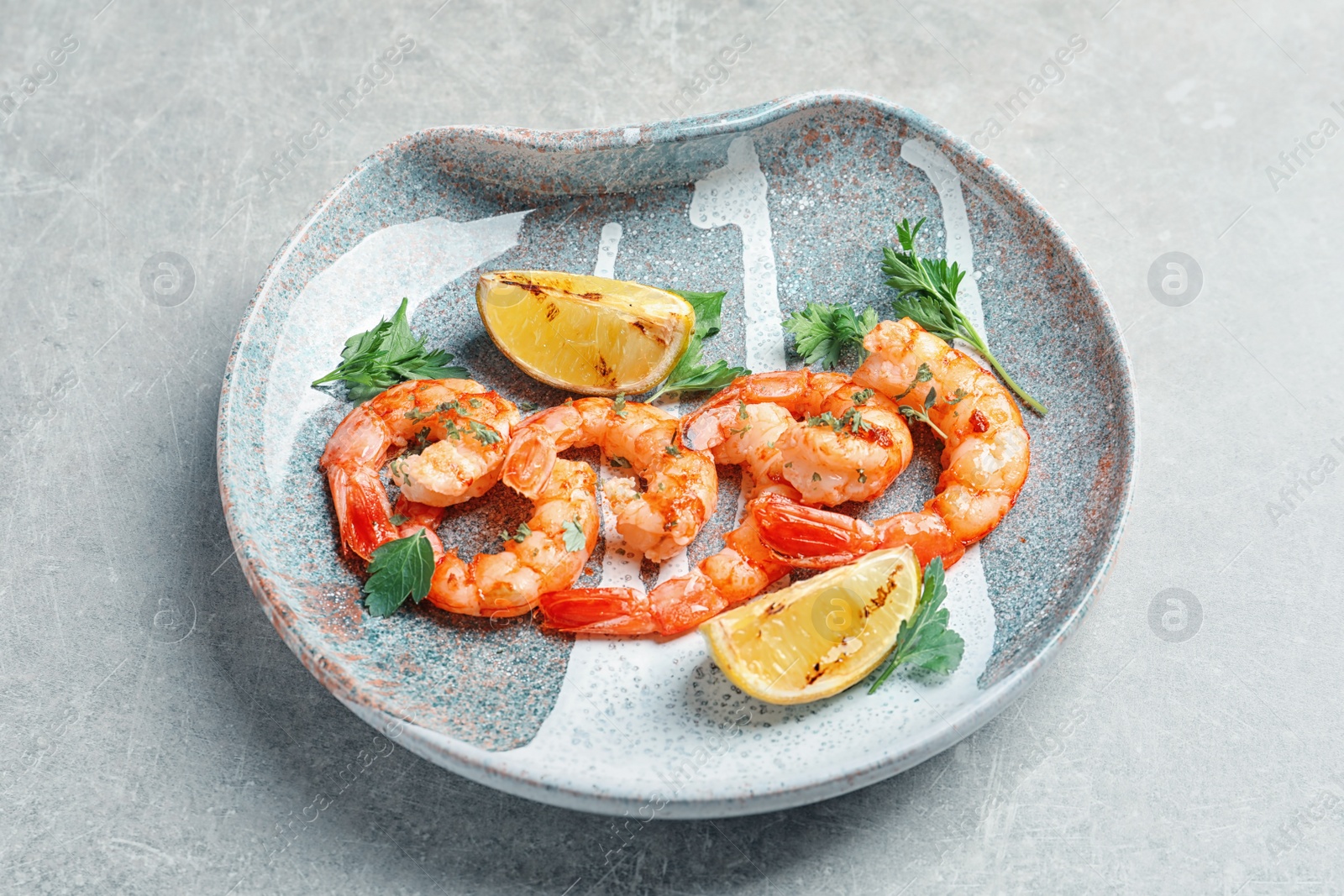 Photo of Plate with delicious fried shrimps and lime on light background