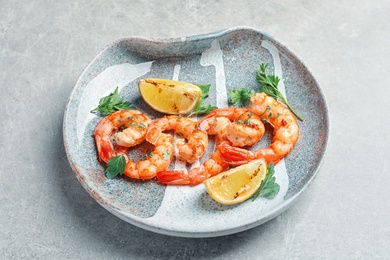 Photo of Plate with delicious fried shrimps and lime on light background