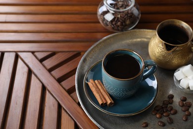Photo of Turkish coffee. Freshly brewed beverage served on wooden table, space for text