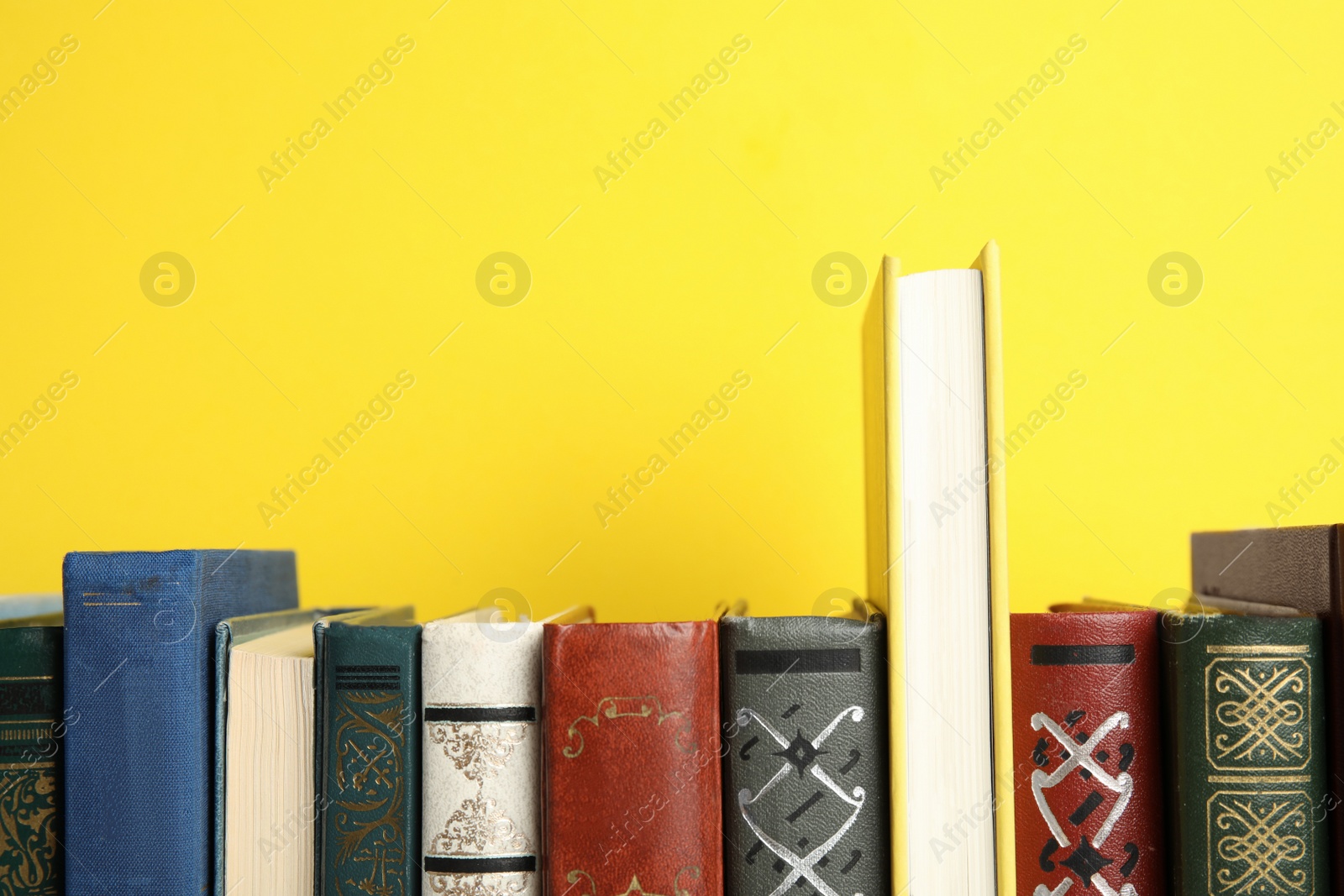 Photo of Collection of old books on yellow background