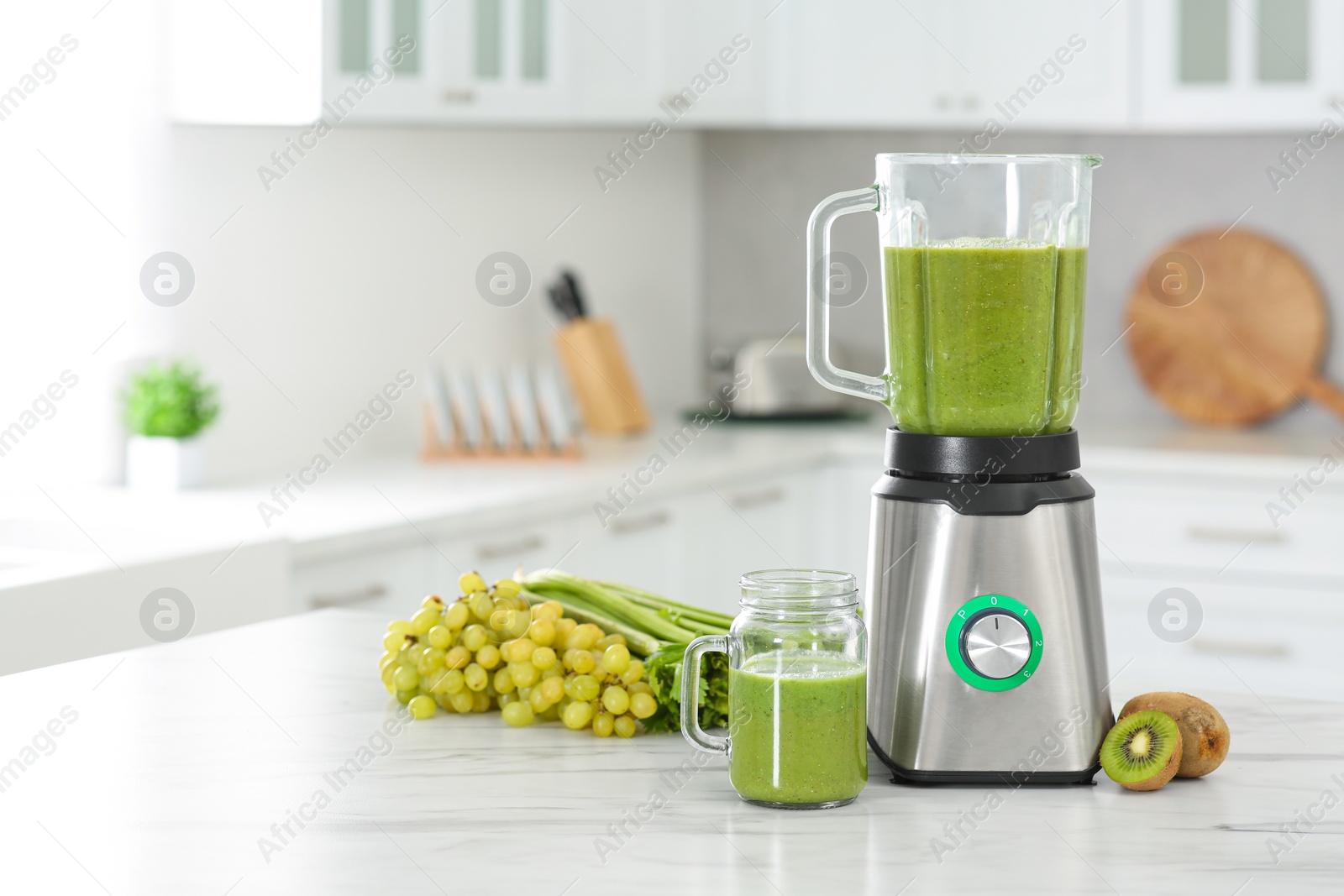 Photo of Delicious fresh smoothie and ingredients on white marble table in kitchen