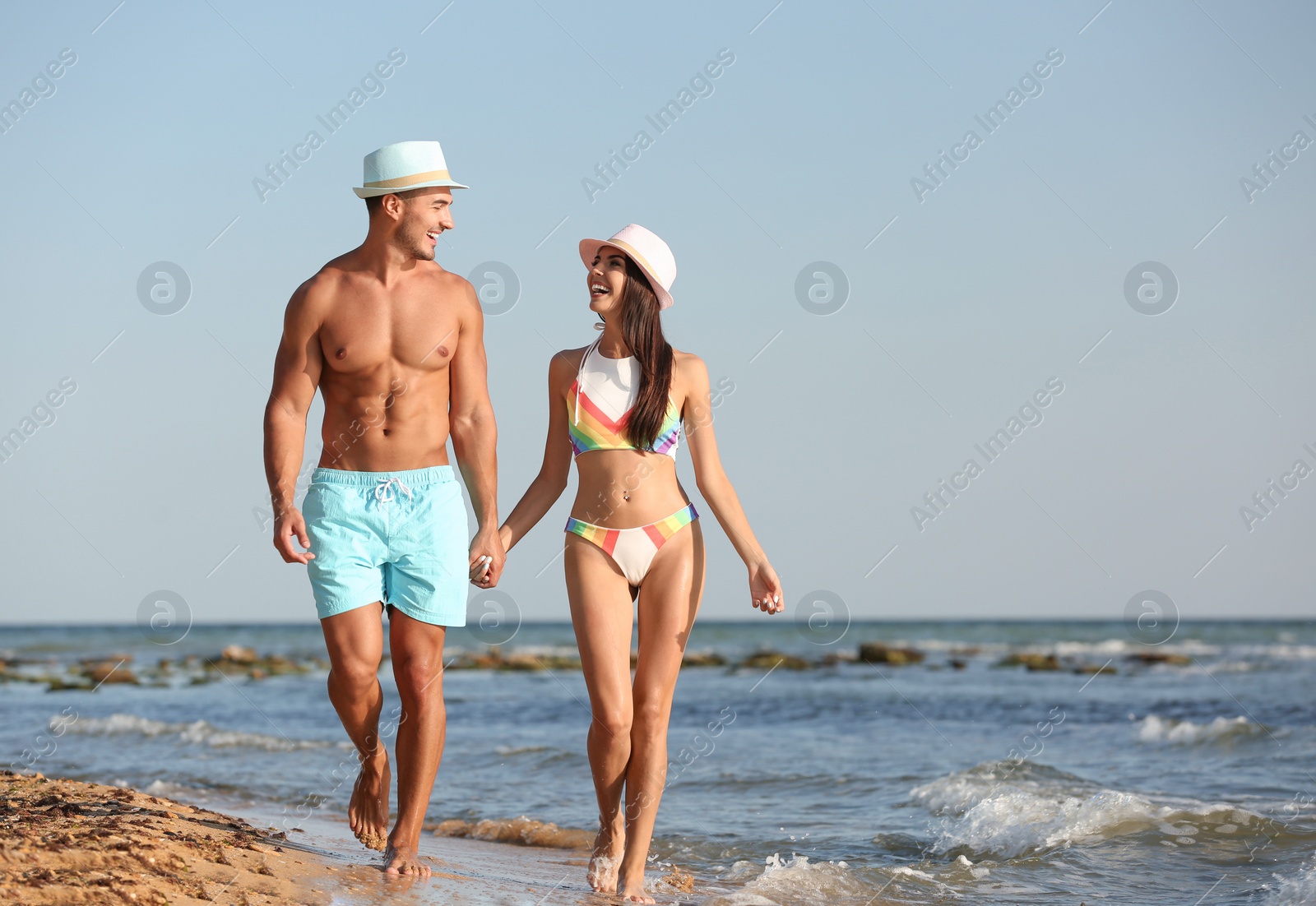 Photo of Happy young couple walking together on beach