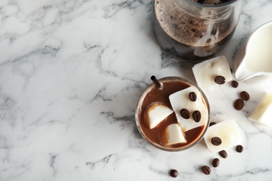 Composition with coffee drink and milk ice cubes on marble background, top view. Space for text