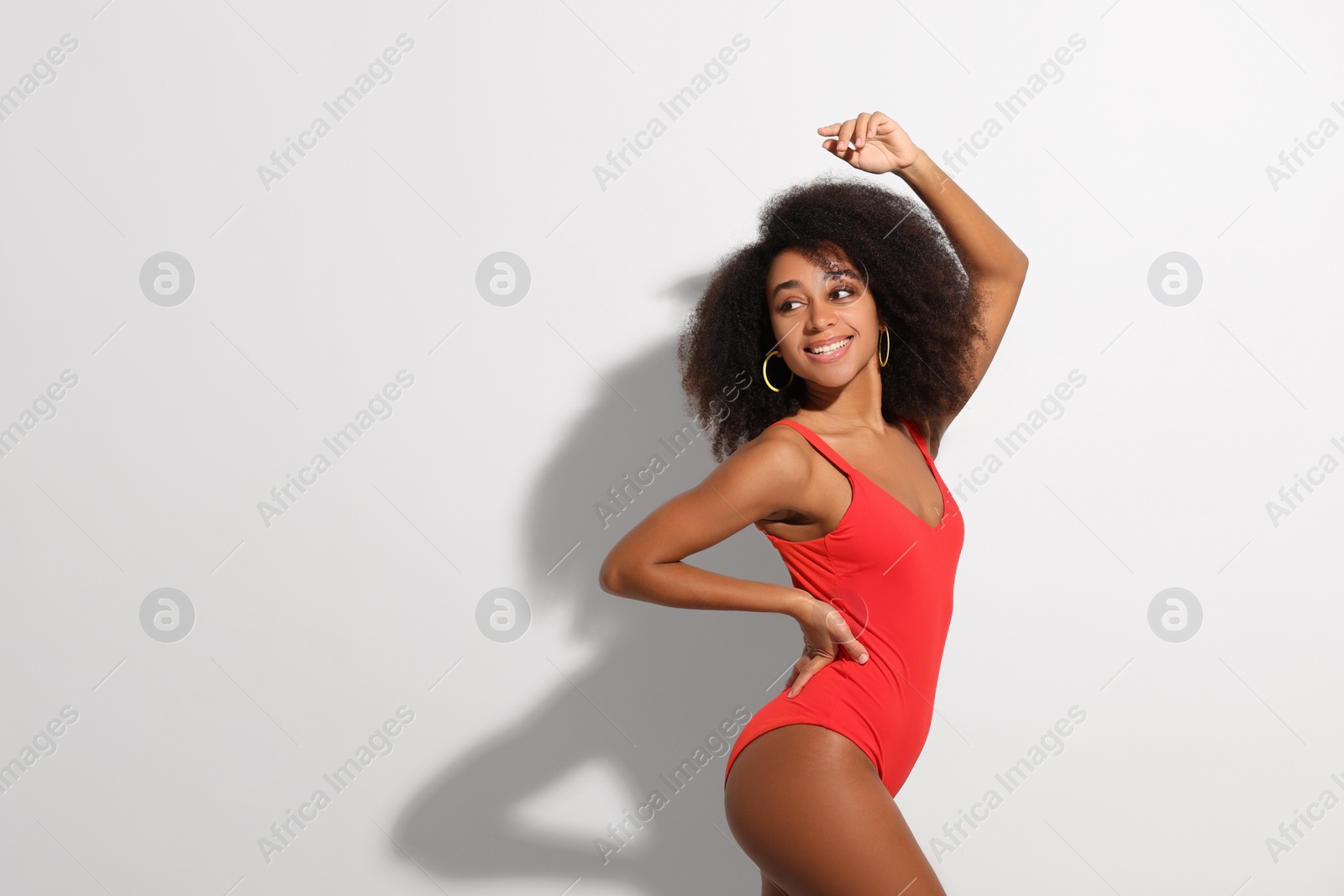 Photo of Beautiful woman in red one-piece summer swimsuit on white background, space for text