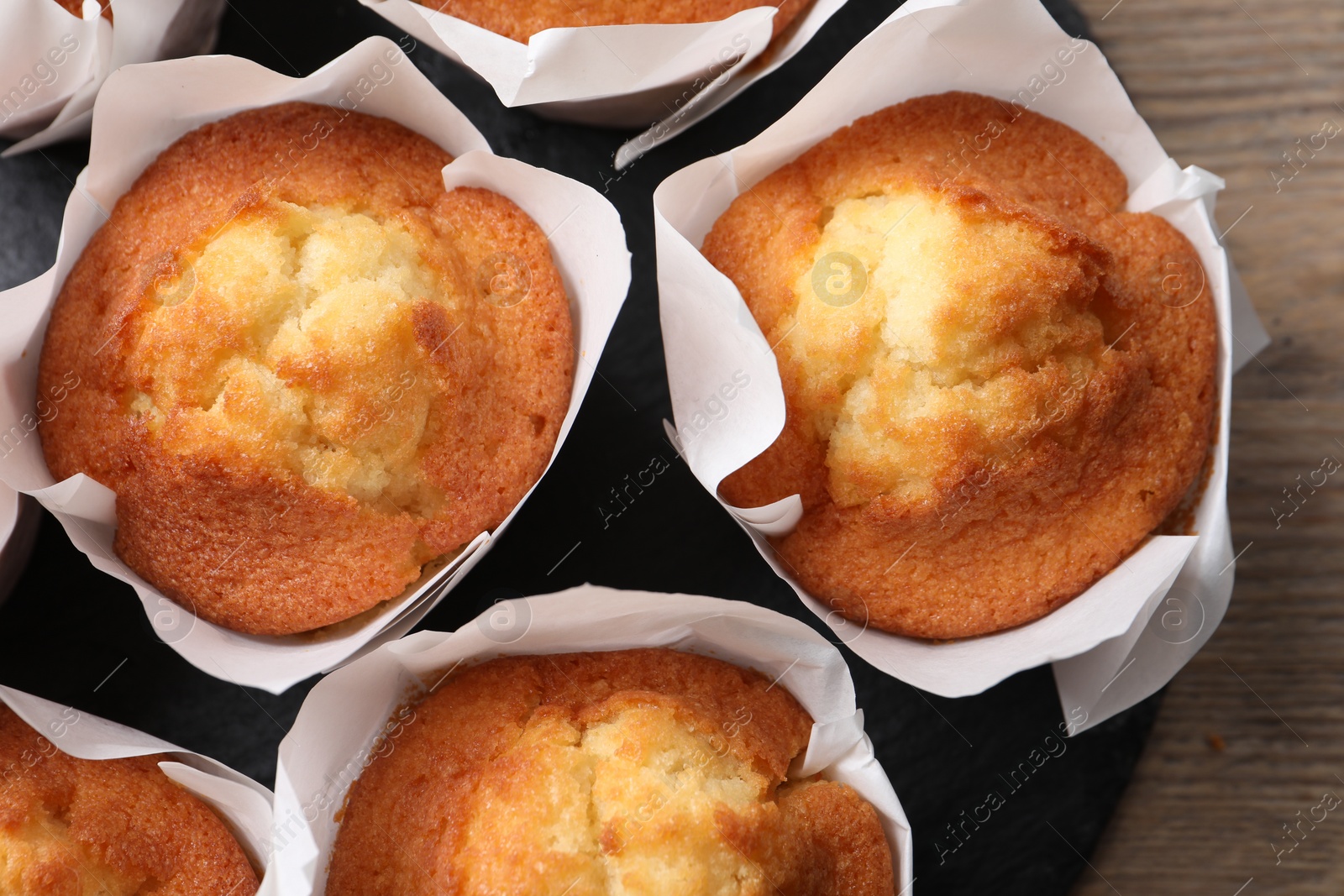 Photo of Delicious sweet muffins on wooden table, top view