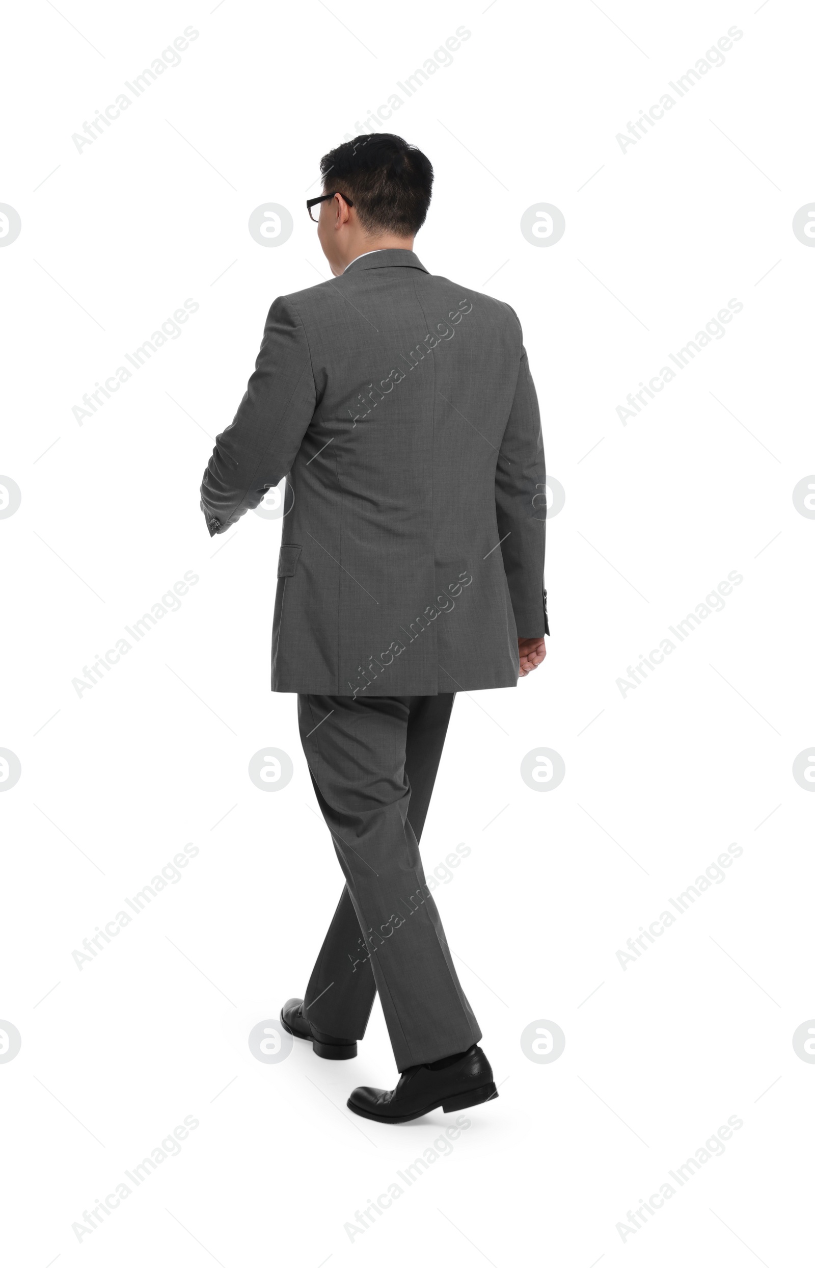 Photo of Businessman in suit walking on white background, back view