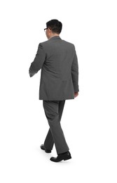 Businessman in suit walking on white background, back view