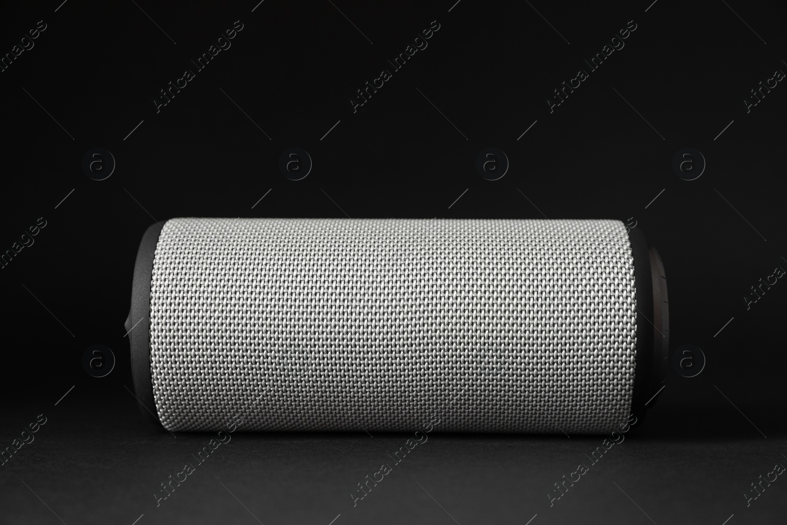 Photo of One portable bluetooth speaker on black background, closeup. Audio equipment