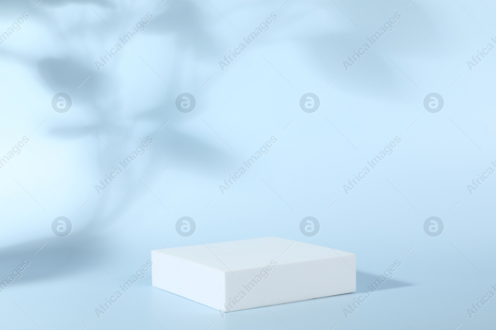 Photo of Presentation of product. White podium on light blue background. Space for text