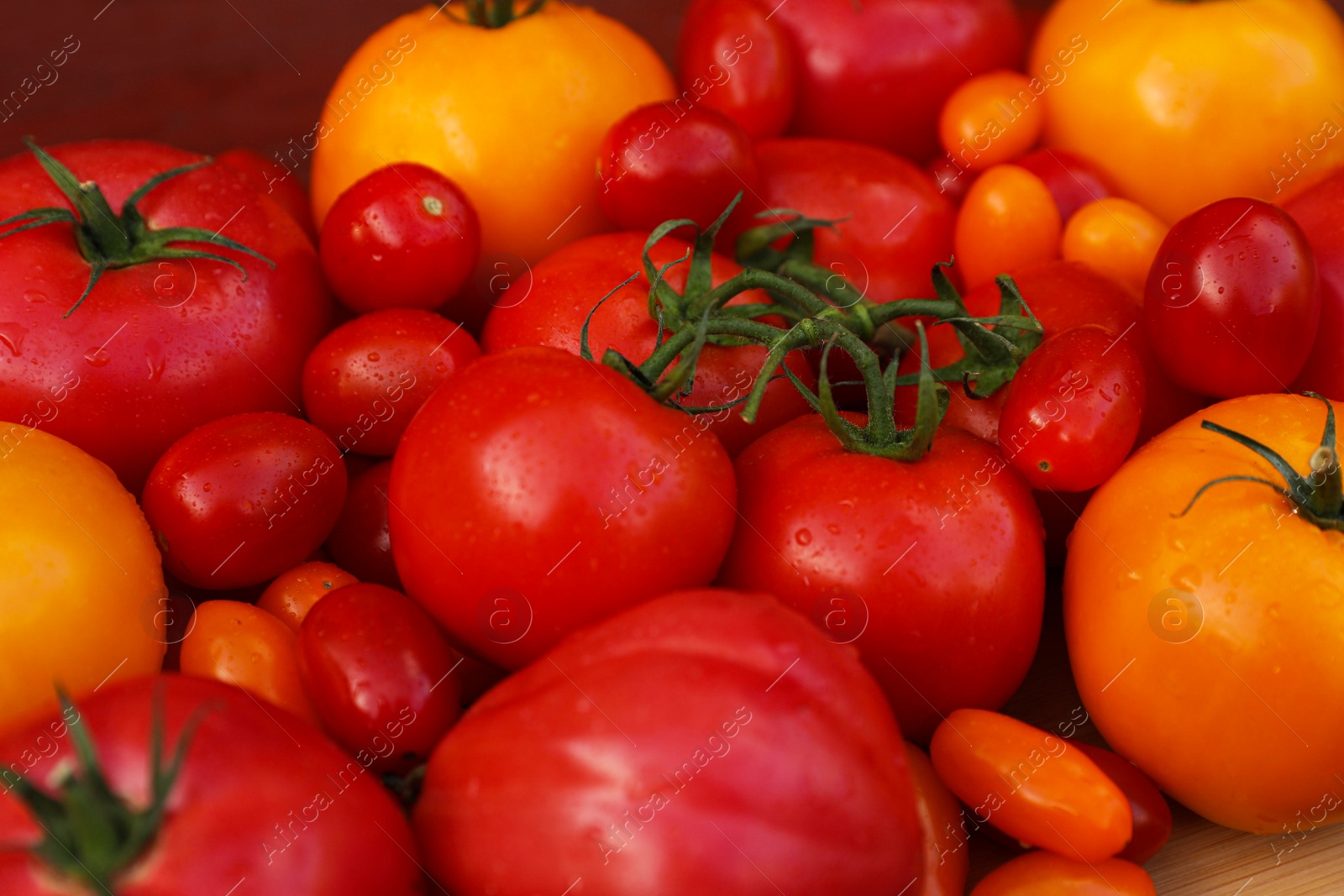 Photo of Many fresh tomatoes on wooden surface, closeup