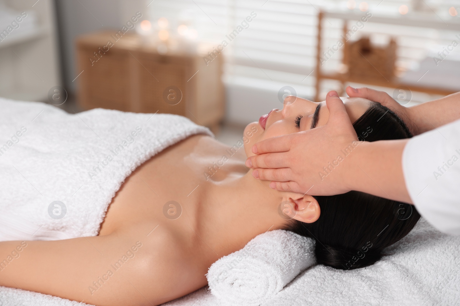 Photo of Beautiful woman receiving massage in beauty salon, closeup