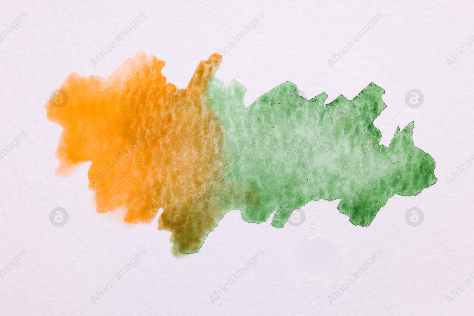 Photo of Blots of bright watercolor paints on white paper, top view