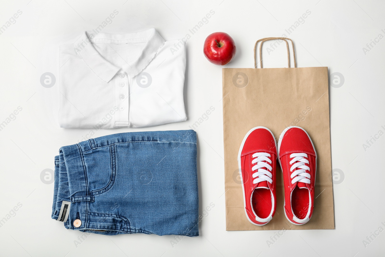 Photo of Stylish flat lay composition with shopping bag and clothing on white background