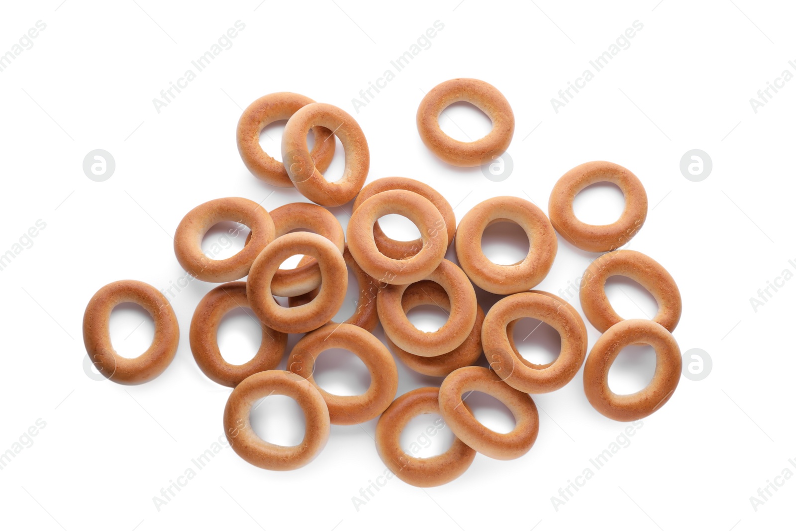 Photo of Many tasty dry bagels (sushki) isolated on white, top view