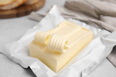 Photo of Tasty butter and curls on light grey table, closeup