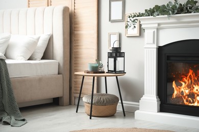 Beautiful eucalyptus garland on fireplace and wooden table in stylish room