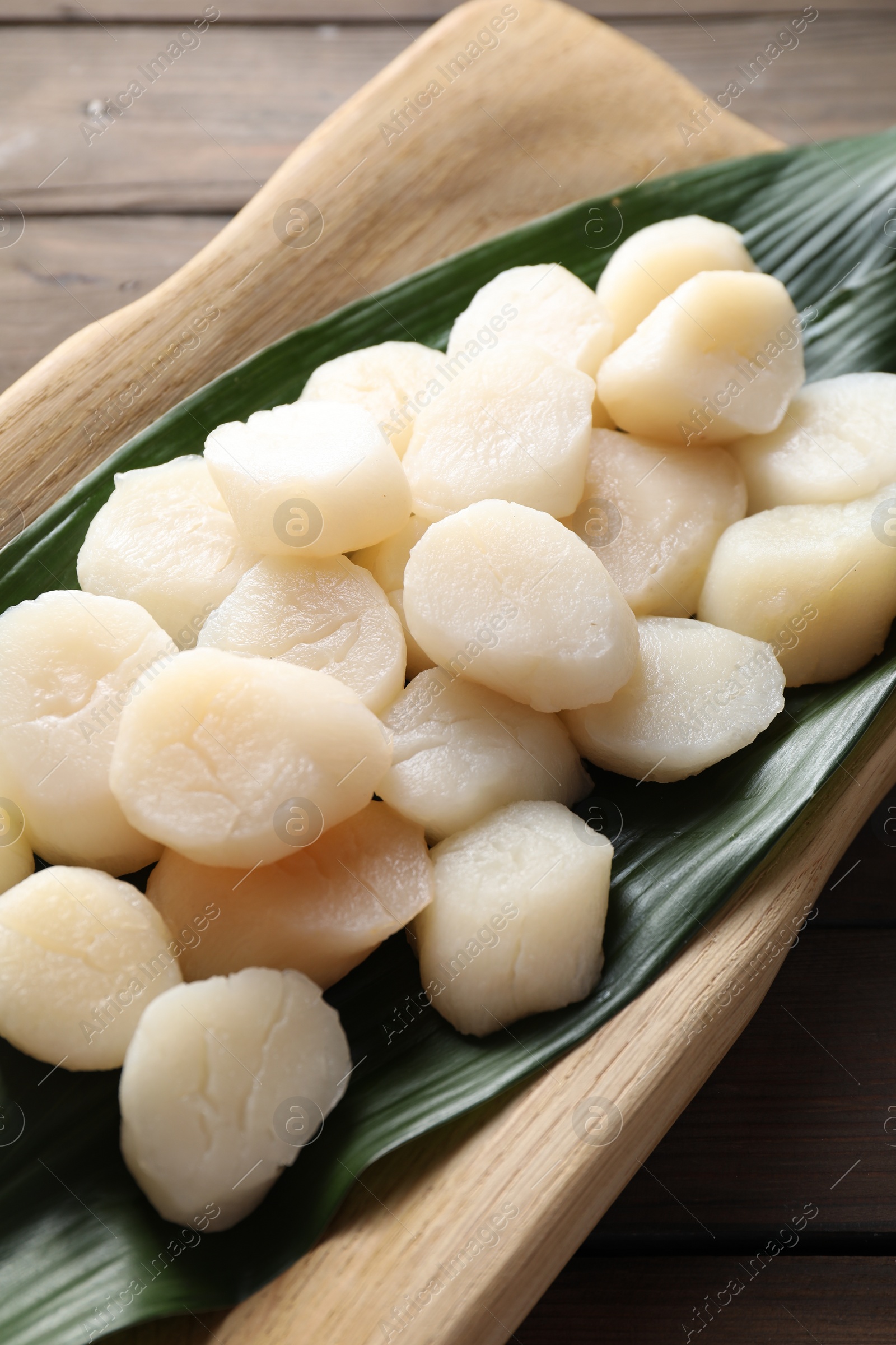 Photo of Fresh raw scallops on wooden table, closeup