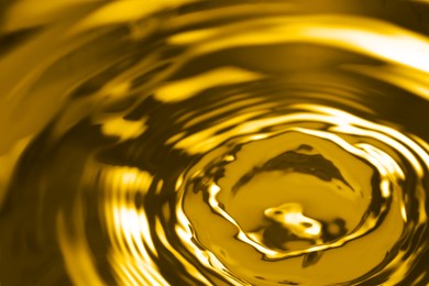 Image of Splash of golden oily liquid as background, closeup