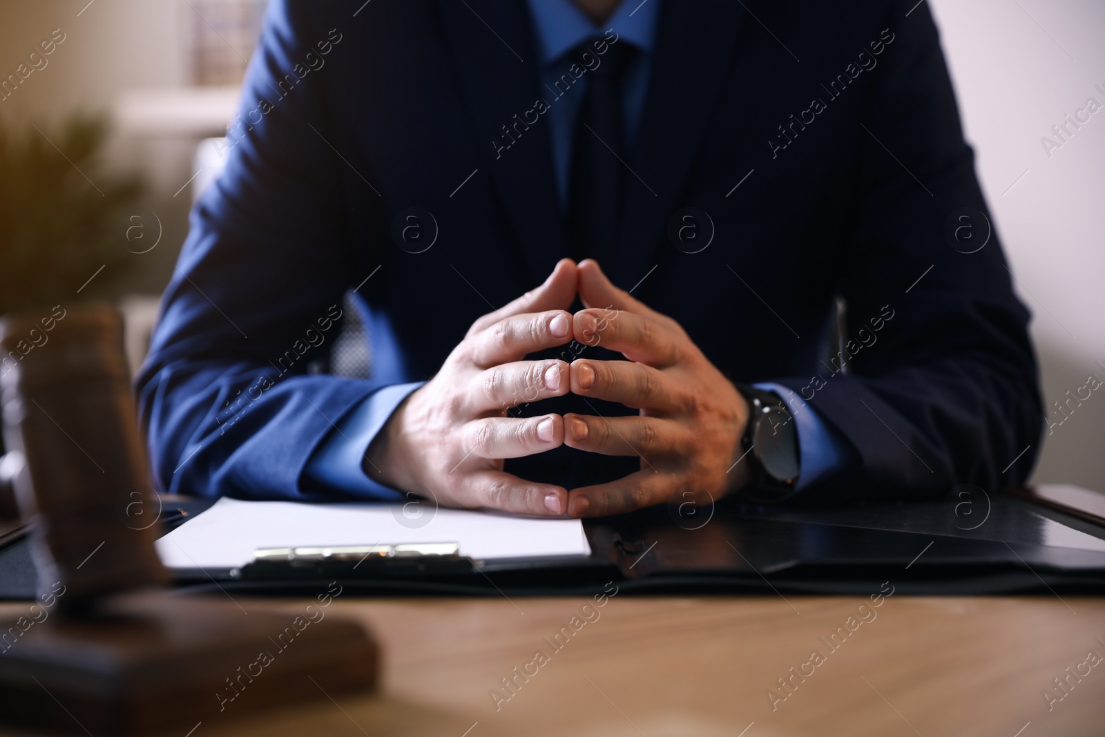 Photo of Male lawyer at table in office, closeup