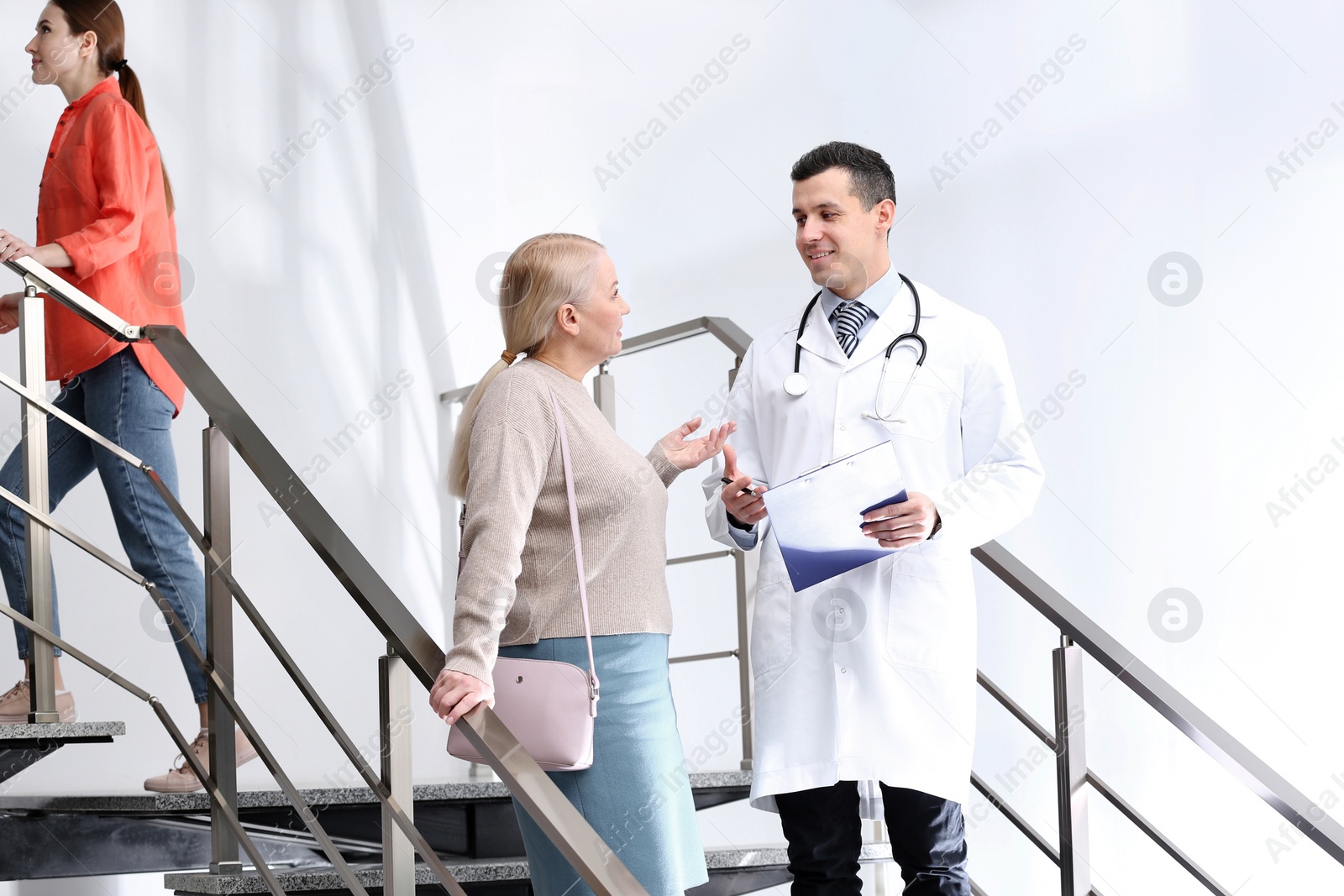 Photo of Doctor and patient discussing diagnosis on stairs in hospital