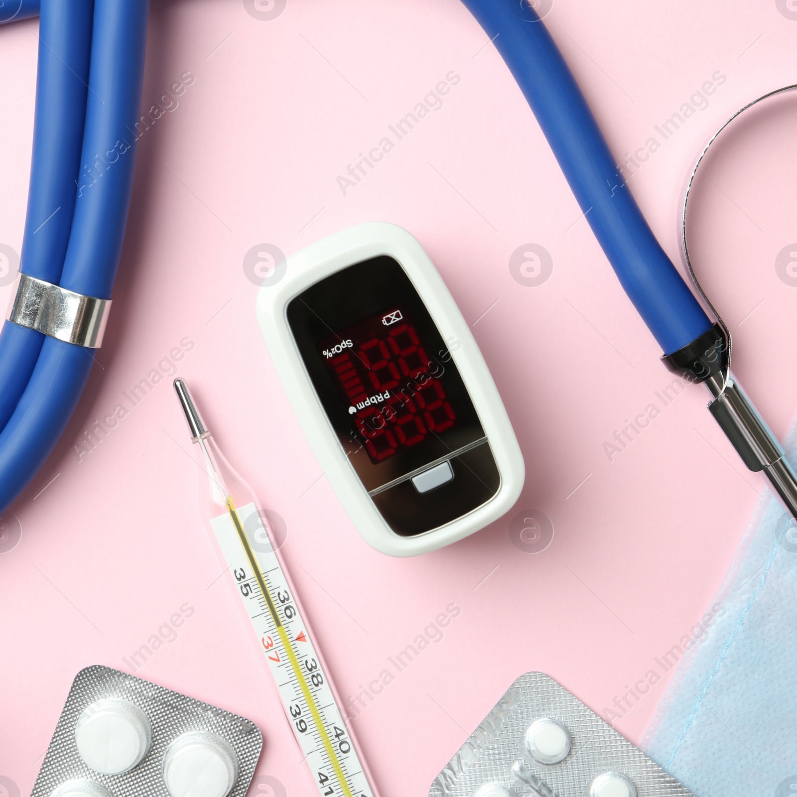 Photo of Flat lay composition with fingertip pulse oximeter and medical items on pink background