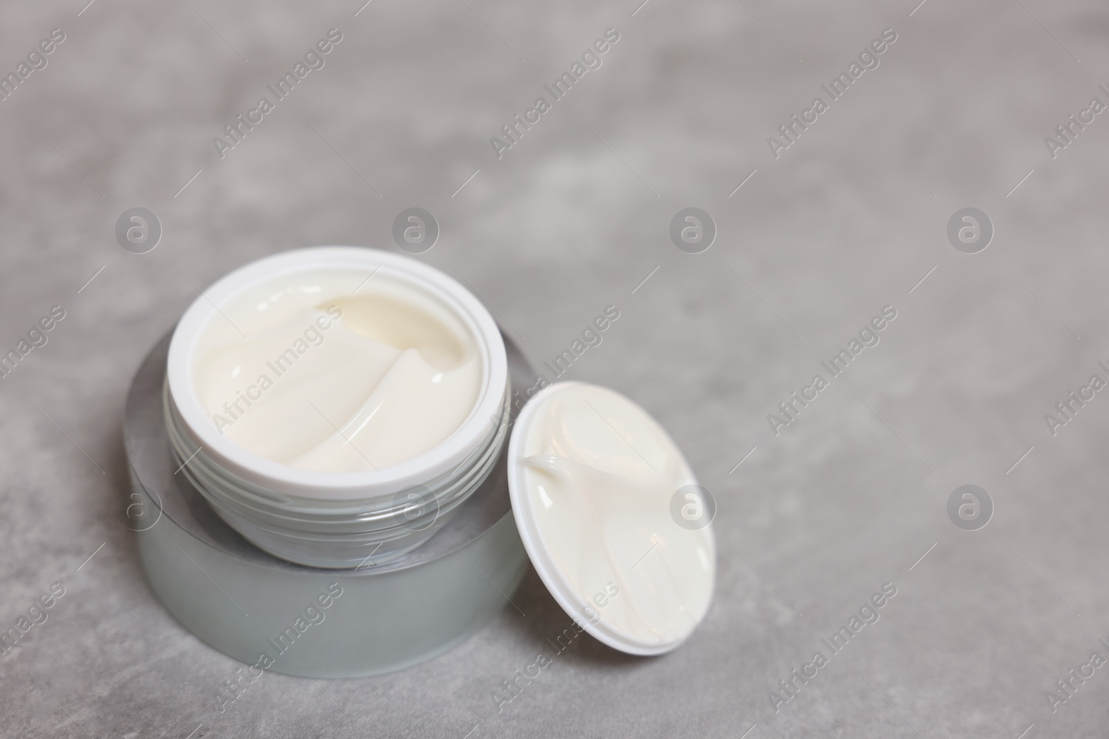 Photo of Body cream on grey table, closeup. Space for text