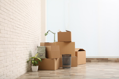 Photo of Moving boxes and stuff near white brick wall in room