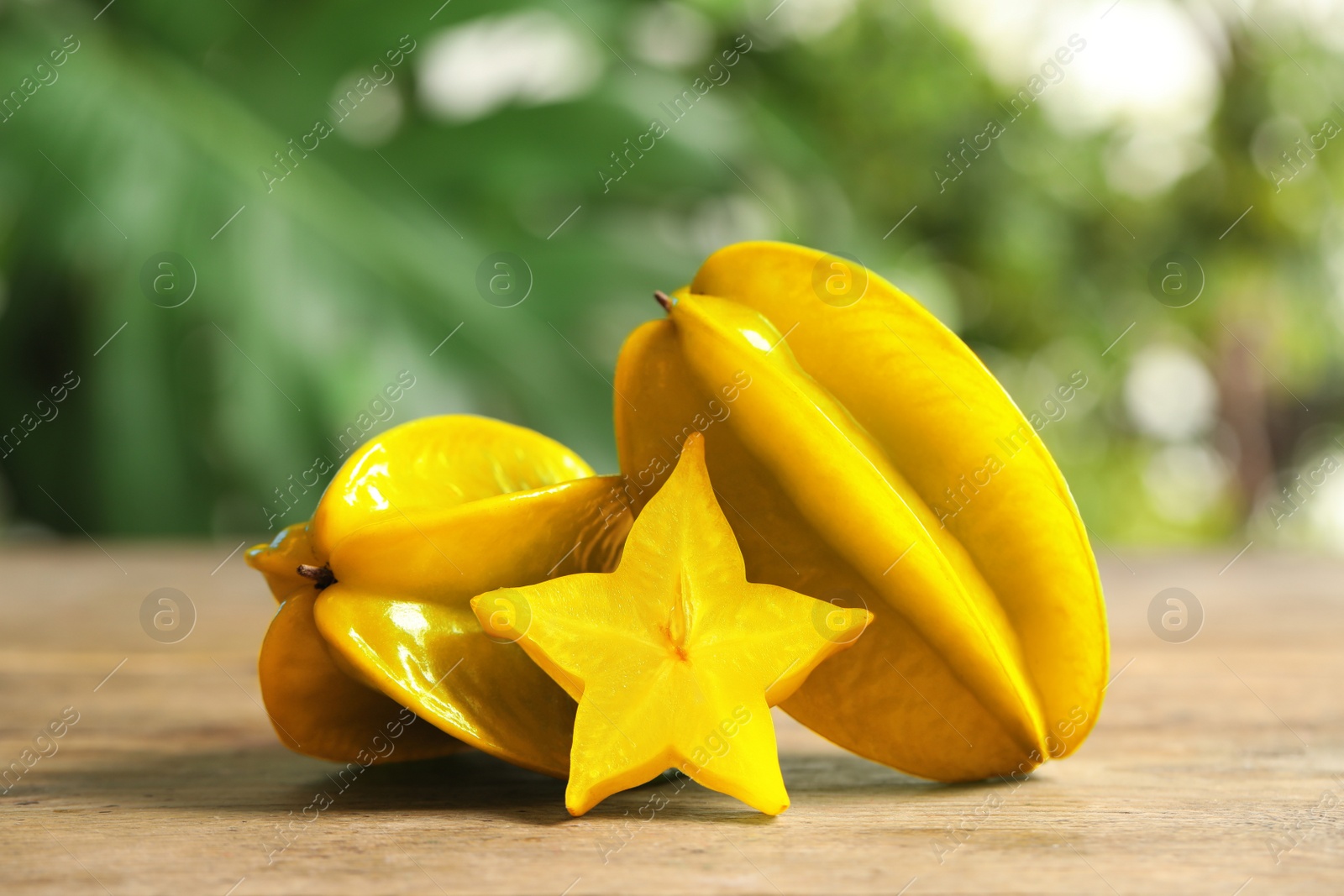 Photo of Delicious carambola fruits and slice on wooden table