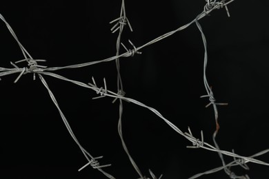 Photo of Shiny metal barbed wire on black background