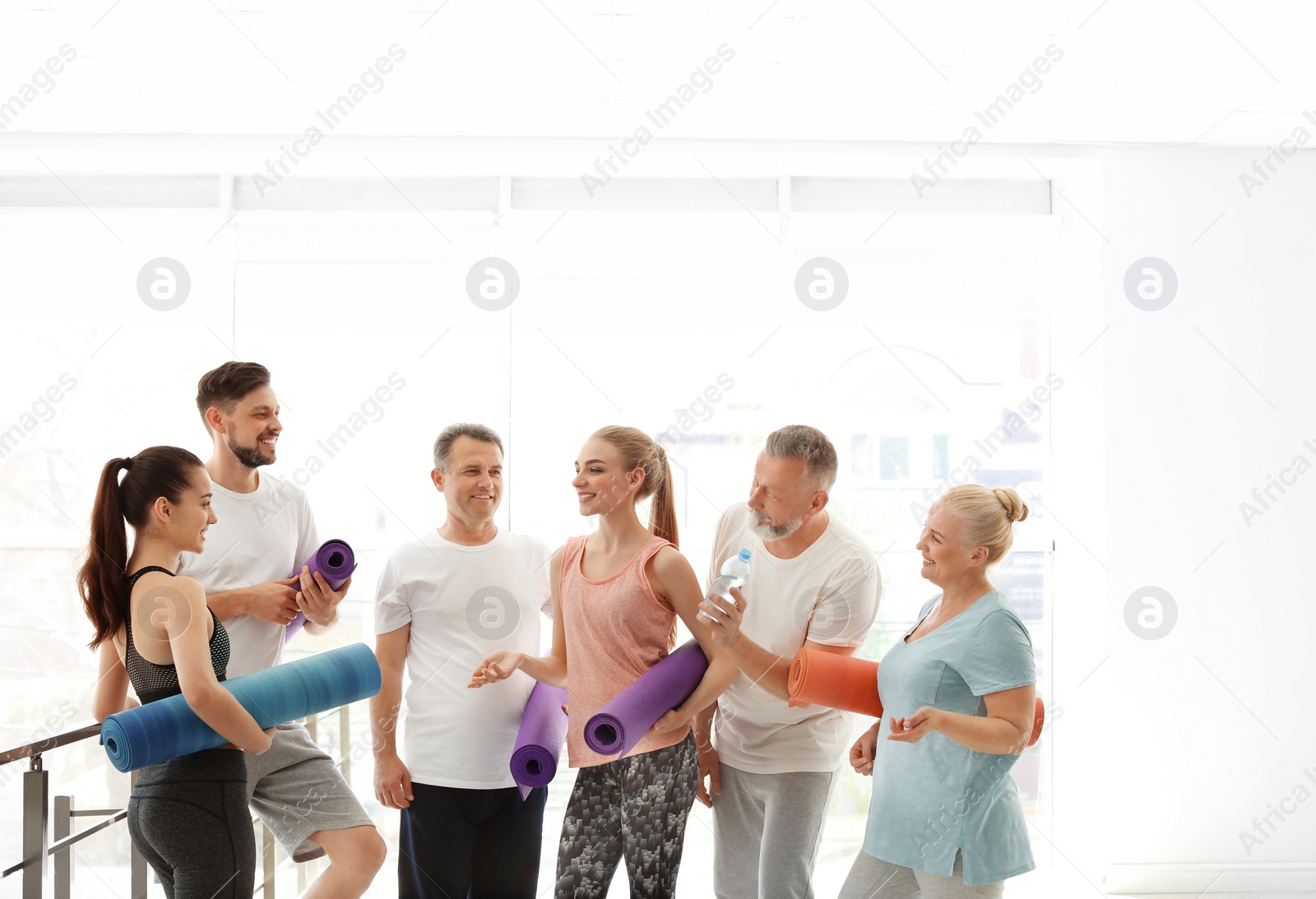 Photo of Group of people talking after yoga class indoors