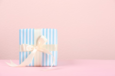 Photo of Beautiful gift box on table against color background