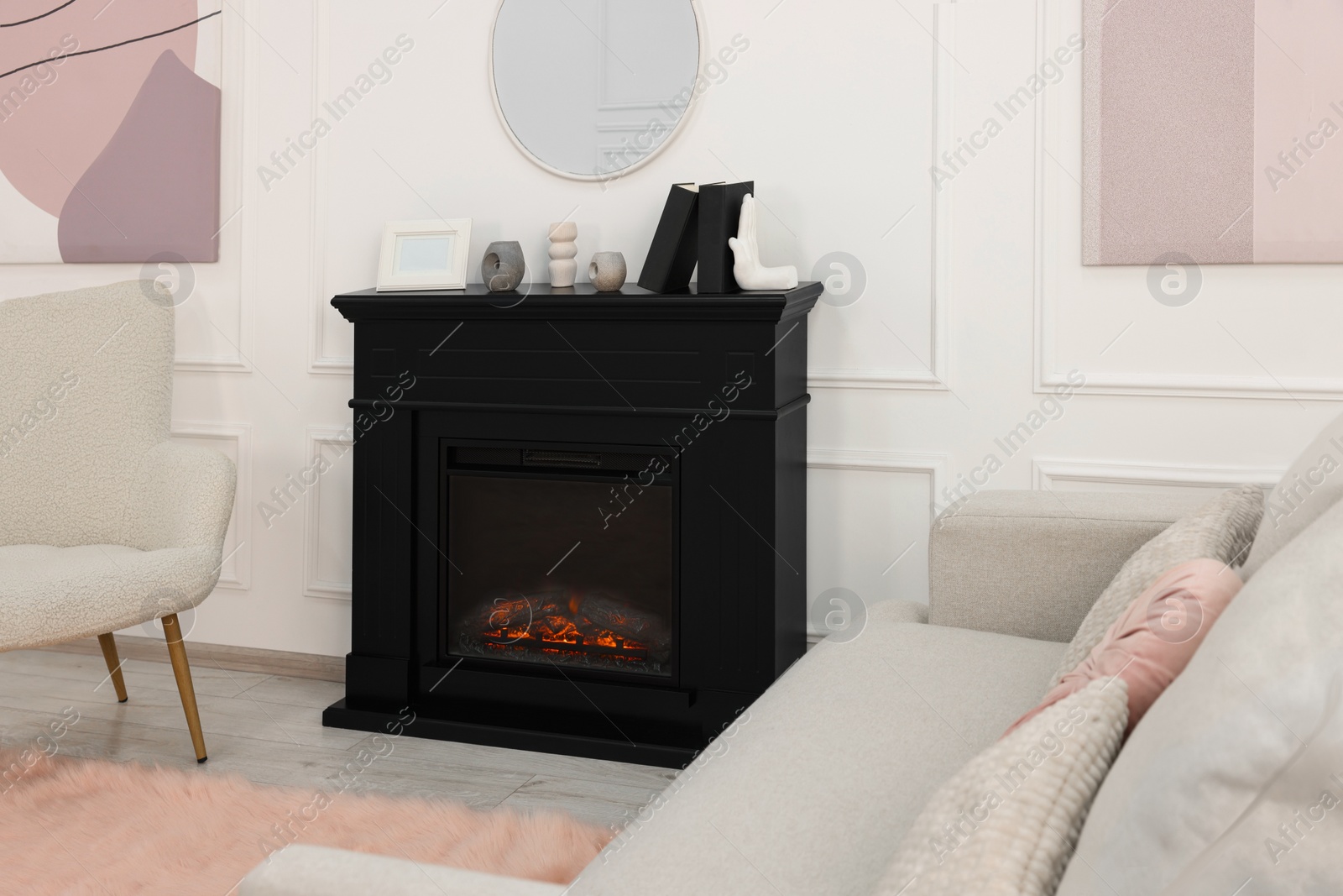 Photo of Black stylish fireplace near comfortable sofa in cosy living room