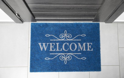 Photo of Beautiful doormat with word Welcome on floor near entrance, top view