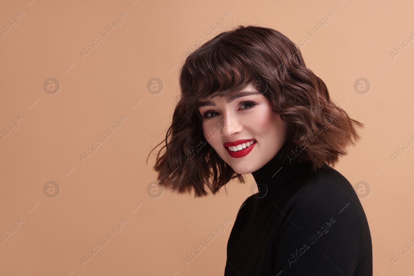 Photo of Portrait of beautiful young woman with wavy hairstyle on beige background. Space for text