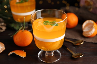 Photo of Delicious tangerine jelly on brown wooden table