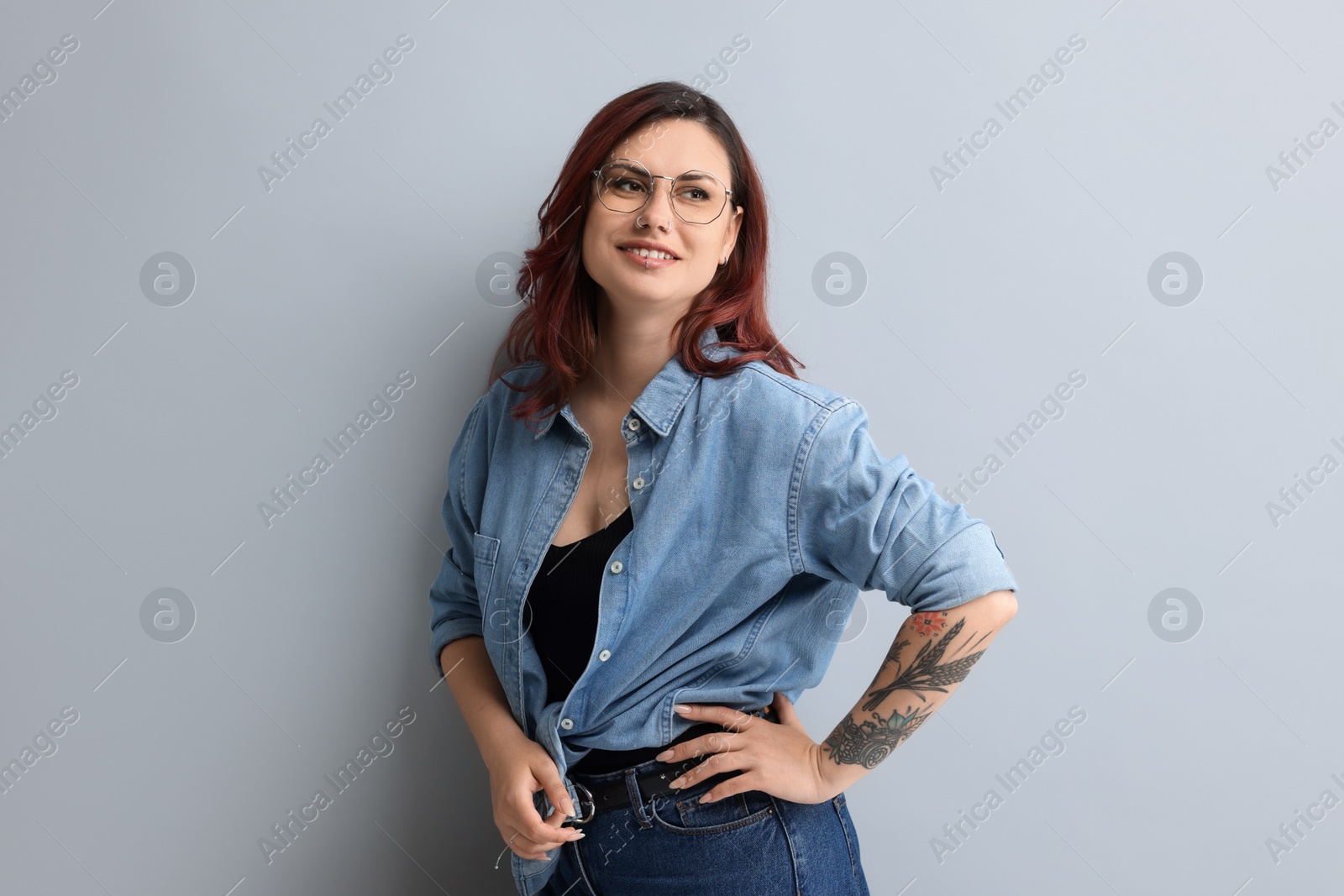 Photo of Portrait of beautiful tattooed woman on gray background