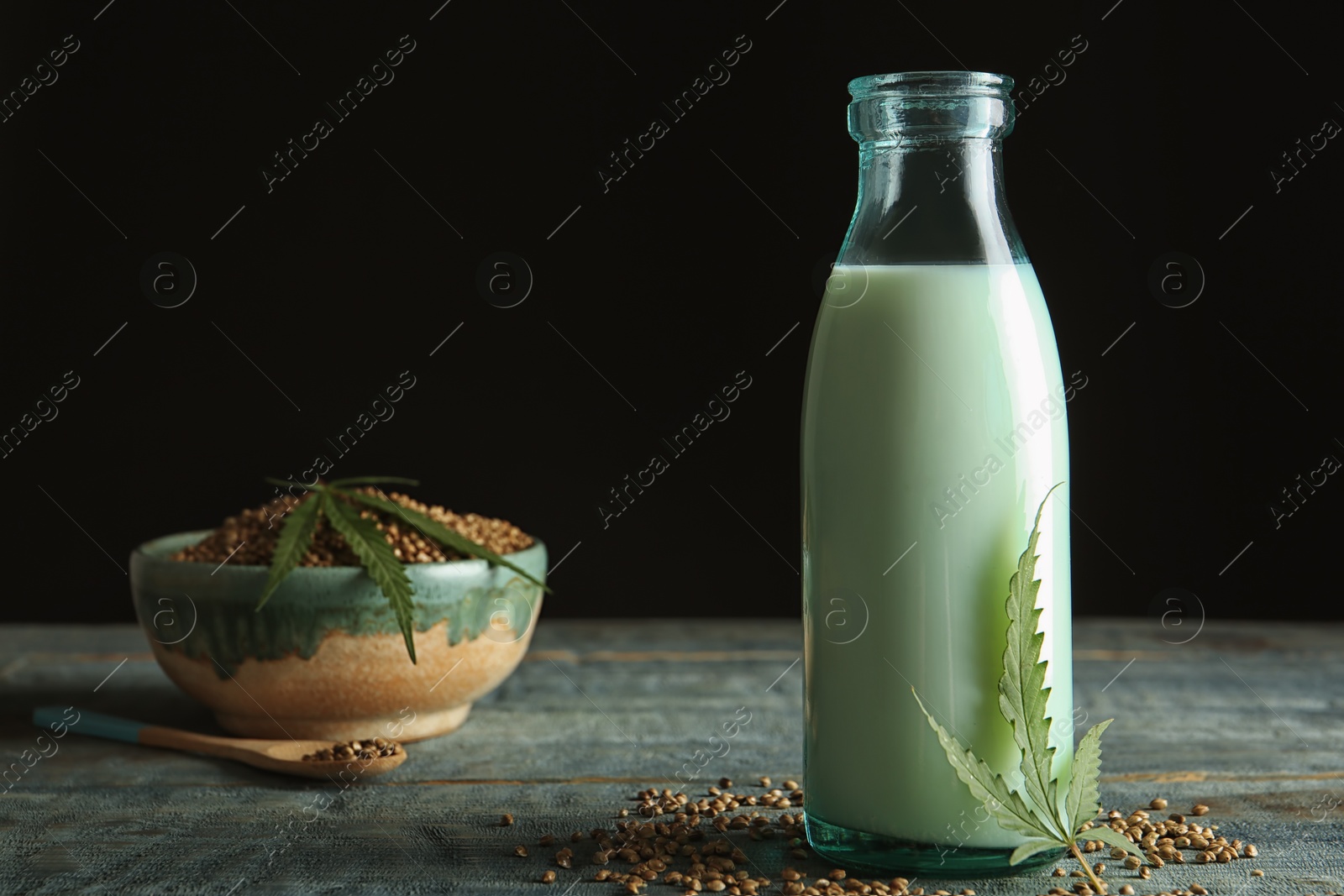 Photo of Bottle of hemp milk on wooden table