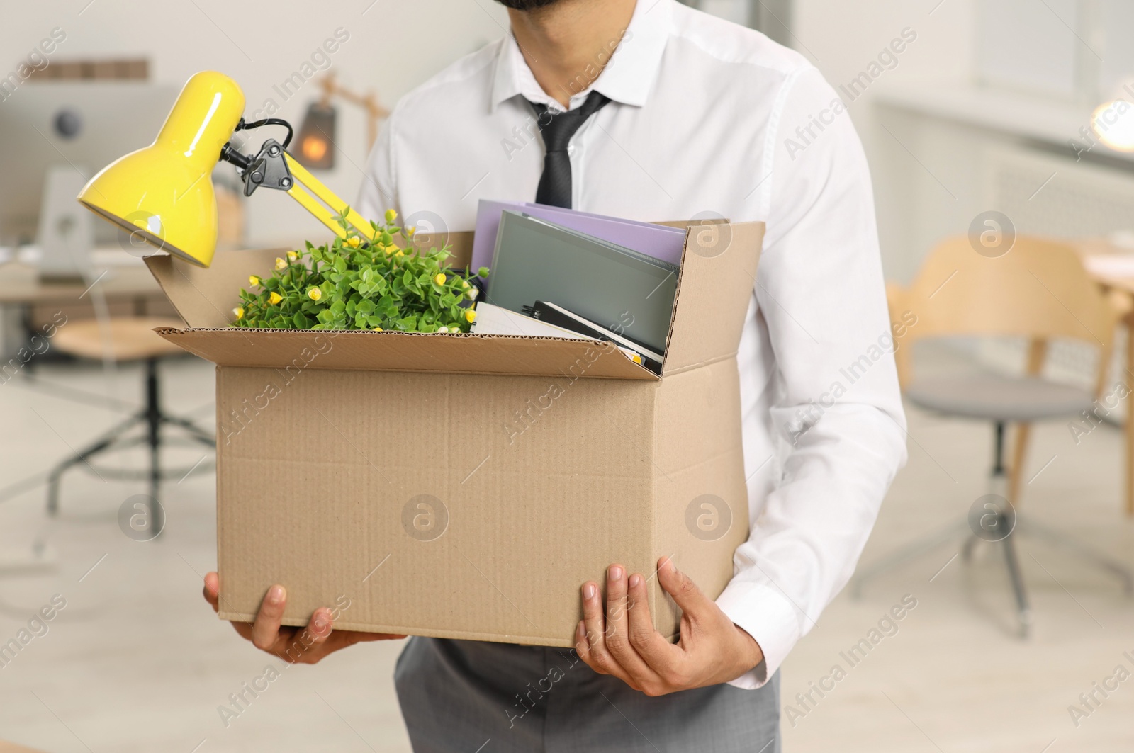 Photo of Unemployment problem. Man with box of personal belongings in office, closeup