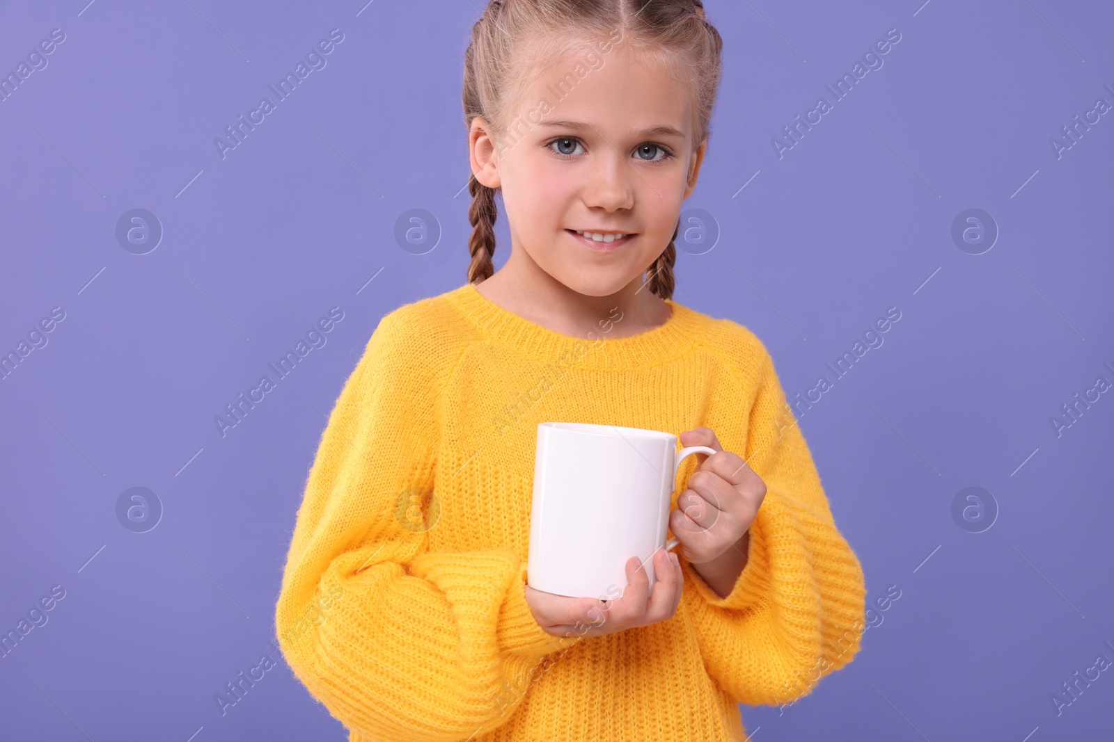 Photo of Happy girl with white ceramic mug on violet background