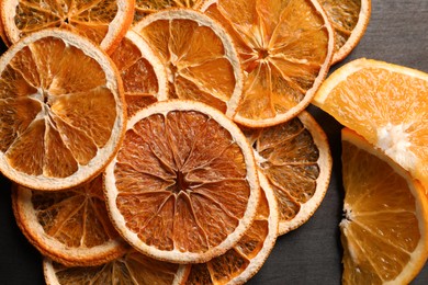 Dry and fresh orange slices on wooden table, flat lay