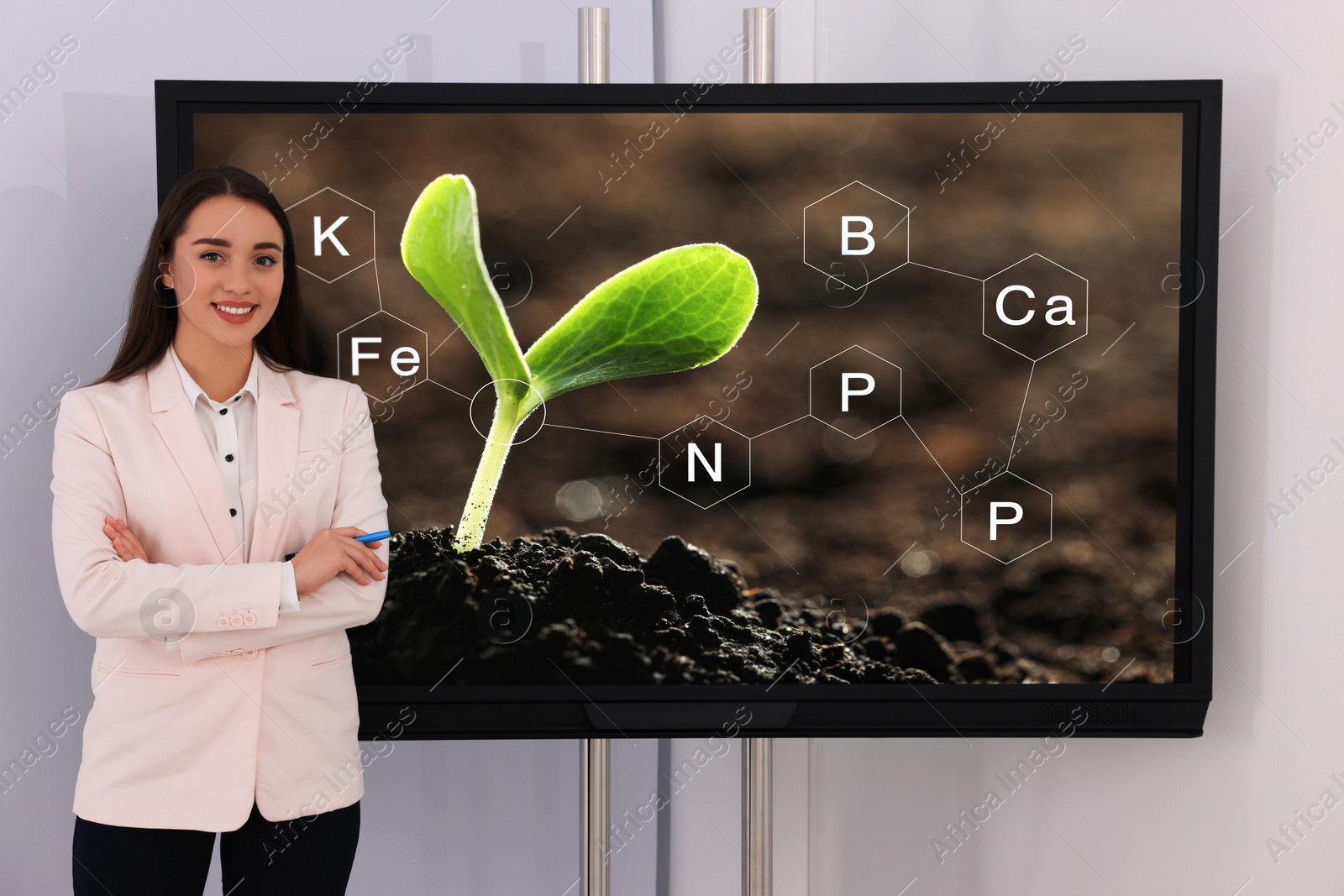 Photo of Teacher near interactive board in classroom during lesson