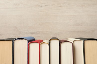 Photo of Many hardcover books on wooden background, space for text