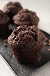 Photo of Delicious chocolate muffins on light table, closeup