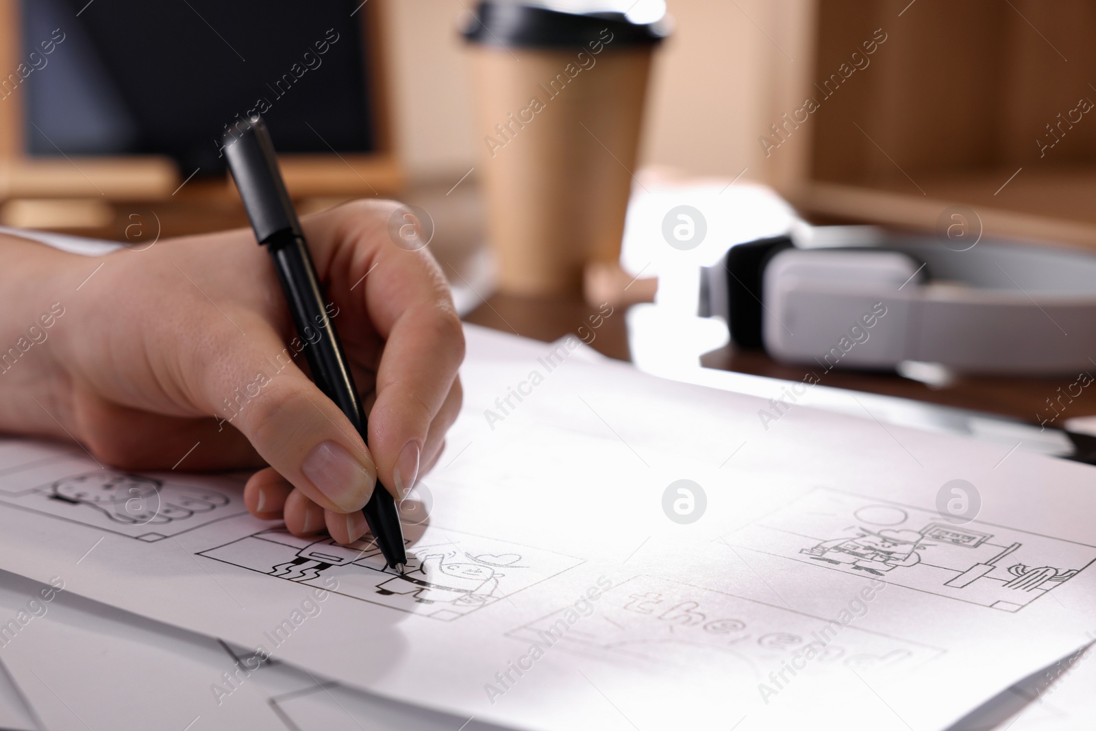 Photo of Woman drawing cartoon sketch at workplace, closeup. Pre-production process