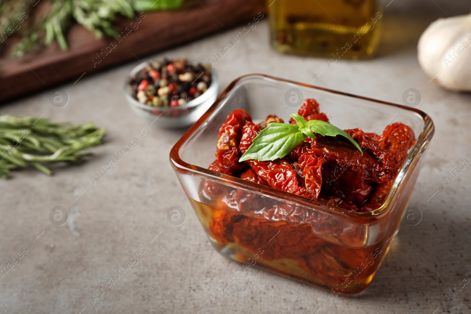 Photo of Bowl with sun dried tomatoes on gray table