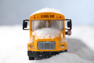 Photo of Yellow school bus on snowy road, closeup. Transport for students